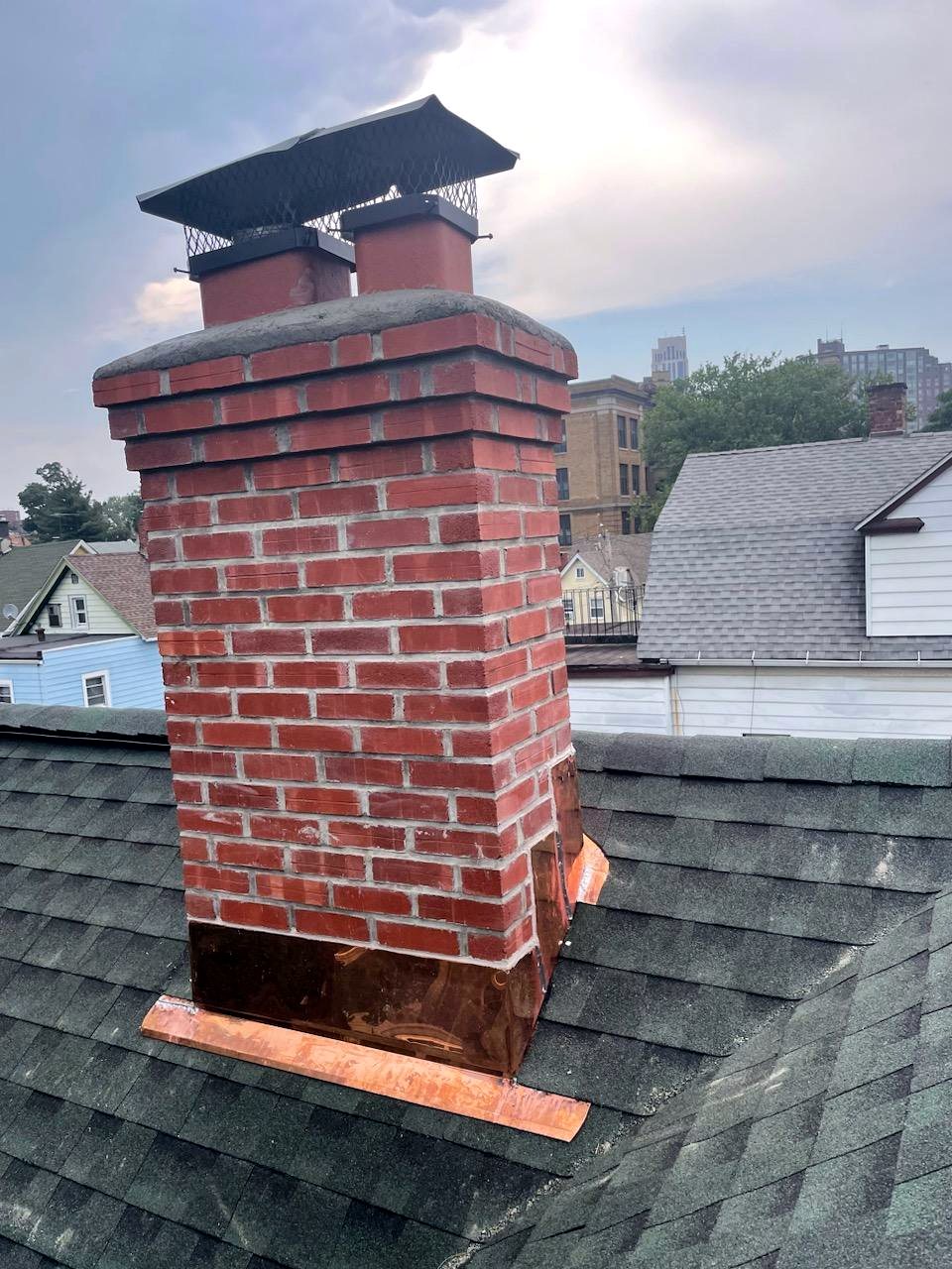 Full brick chimney rebuild with new copper flashing and cricket in Westchester, NY